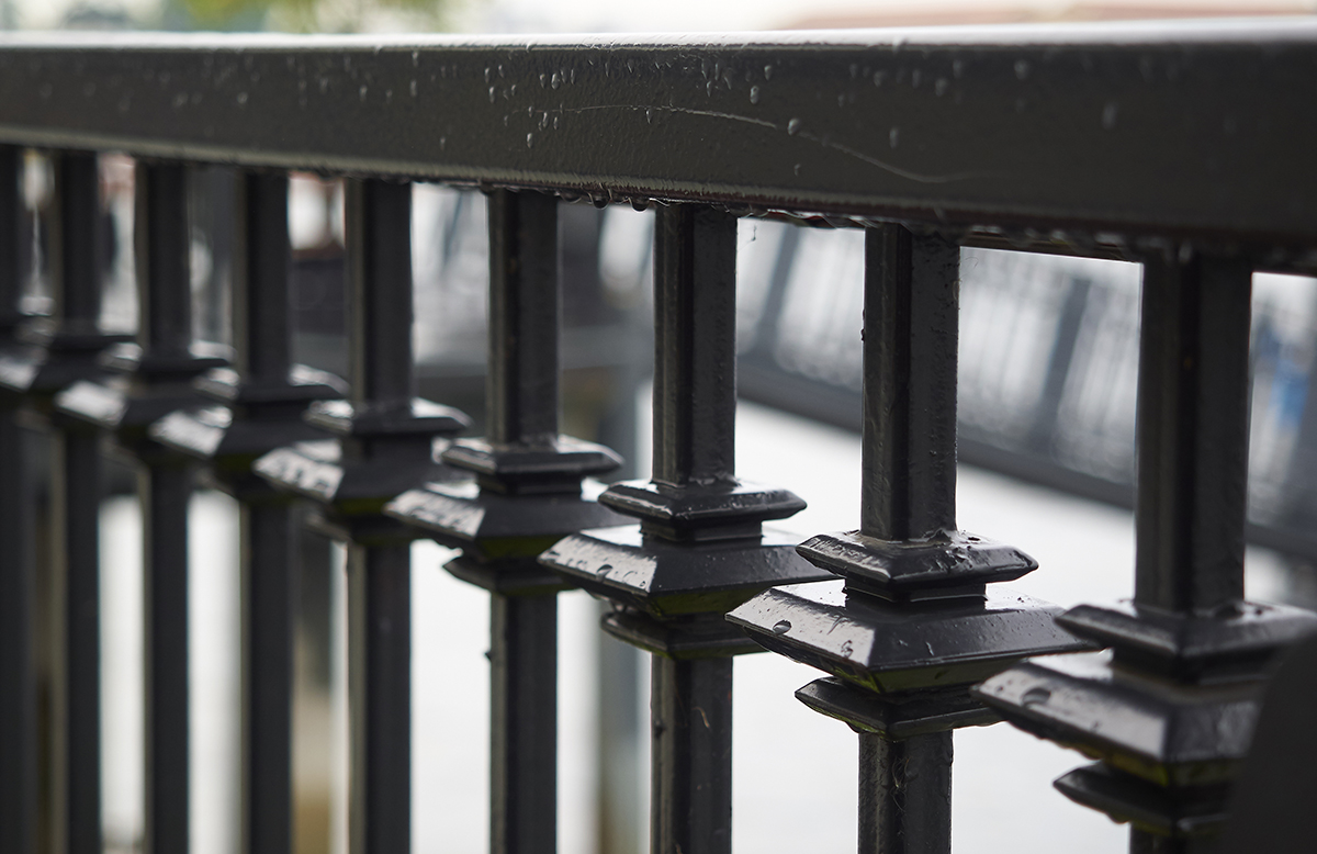 close up line of wrought-iron fence spikes
